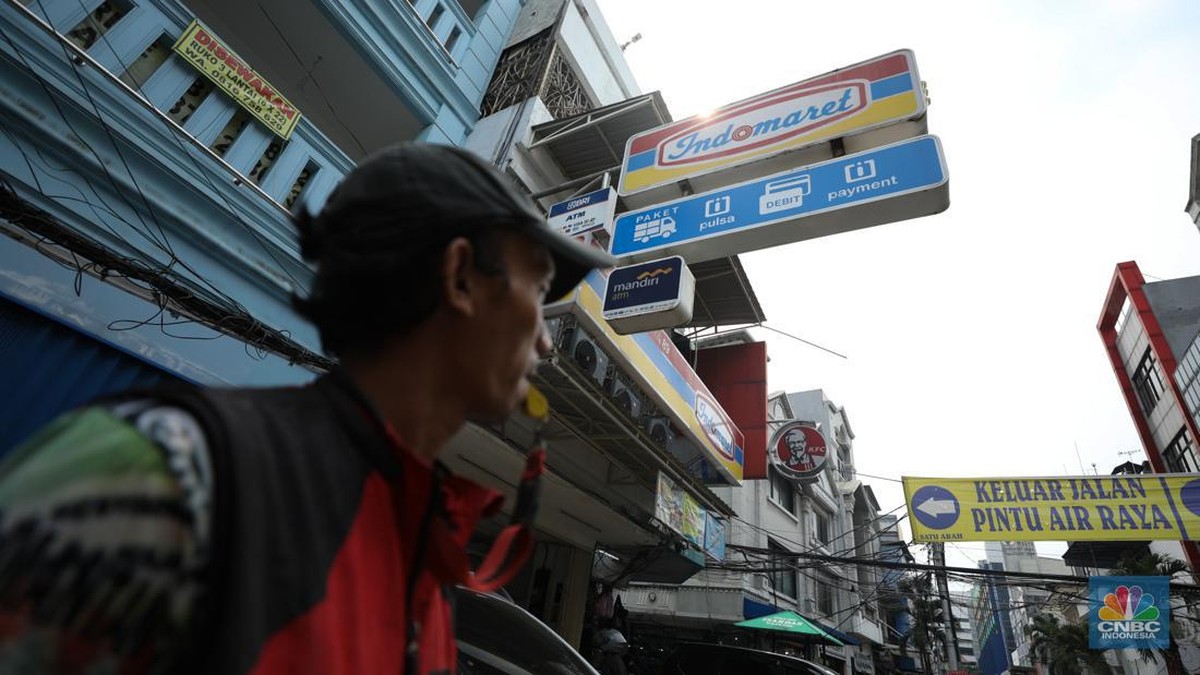 Foto: Aktivitas seorang warga menjaga kendaraan di salahsatu minimarket di kawasan Jakarta, Rabu (8/4/2024). (CNBC Indonesia/Tri Susilo)