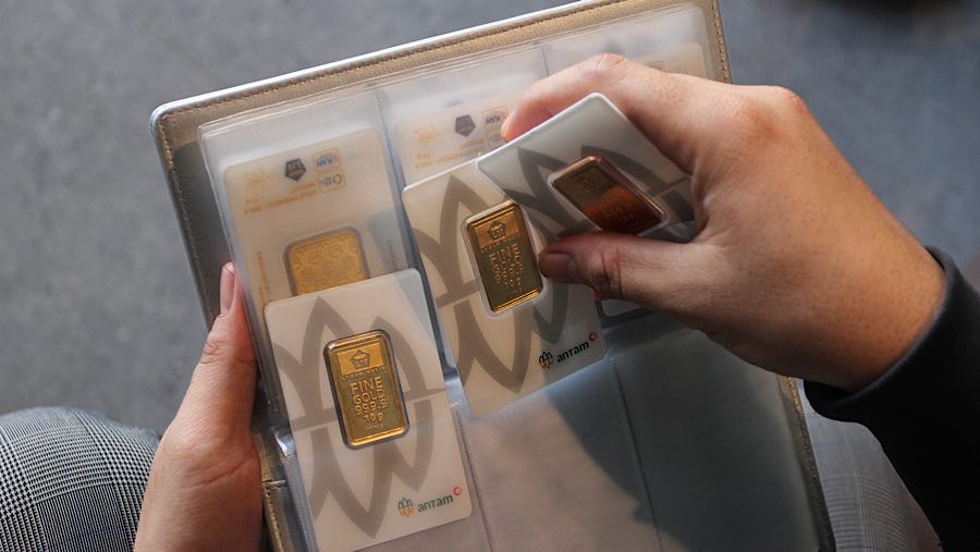 Karyawan meletakkan Logam Mulia kedalam dompet di Butik Emas Antam, Pulogadung, Kamis (10/4/2025). (Bloomberg Technoz/Andrean Kristianto)
